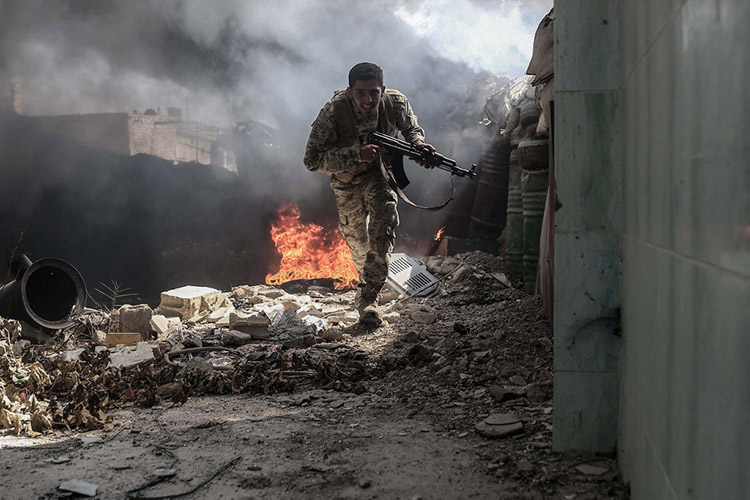 A fighter from the Jaish al-Islam (Islam Army) runs to avoid sniper fire, in the area of the rebel-held stronghold of Douma, on the outskirts of Damascus. Photo taken by Sameer Al-Doumy